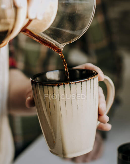 Barista gießt in eine Kaffeemühle — Stockfoto
