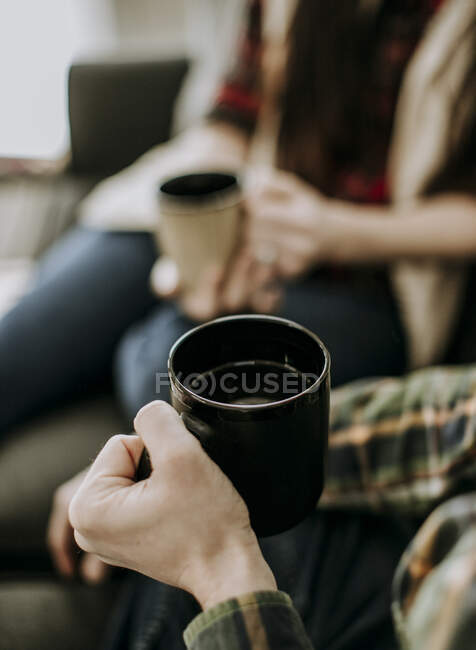 Großaufnahme von zwei Personen, die Kaffeetassen in der Hand halten. Selektiver Fokus — Stockfoto