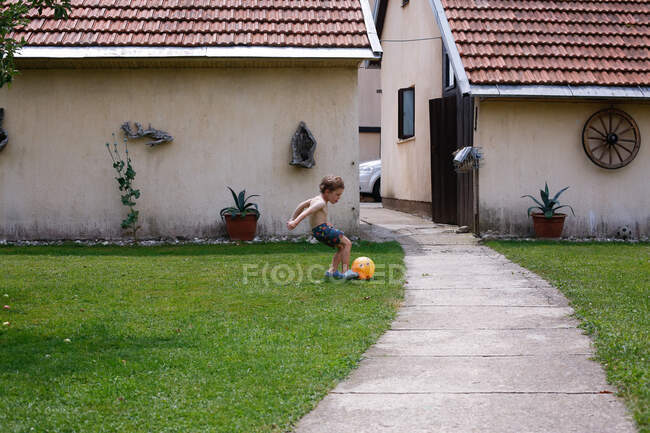 Хлопчик грає футбол у своєму дворі в Свомсуї — стокове фото