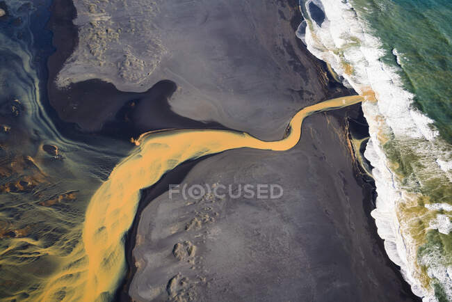 Vista aérea del río naranja trenzado que fluye hacia el océano en el sur — Stock Photo