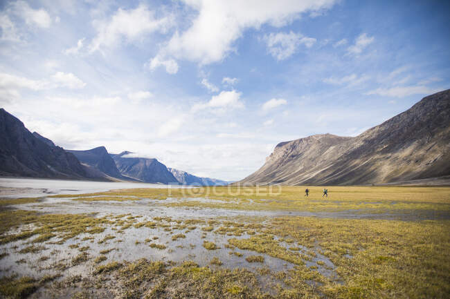Dos turistas masculinos que viajan en las montañas Baffin, Canadá. - foto de stock
