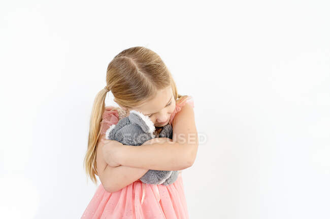 Blond little girl hugging koala stuffed animal indoors — Stock Photo