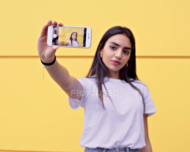 Mujer árabe joven hace una selfie con su teléfono inteligente - foto de stock