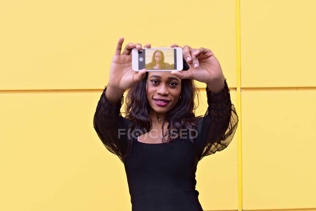 Young African woman makes a selfie with her smartphone — Stock Photo