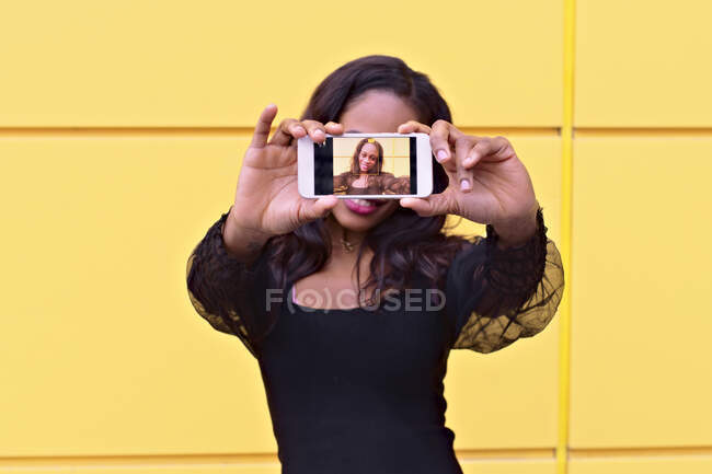 Young African woman makes a selfie with her smartphone — Stock Photo
