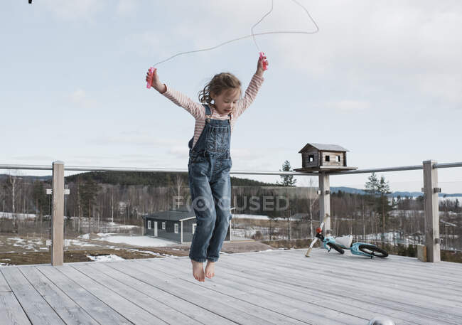 Girl skipping on her balcony outside in Sweden — Stock Photo