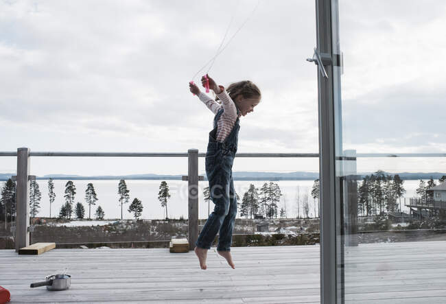 Menina pulando em sua varanda em casa sobre olhando o mar — Fotografia de Stock