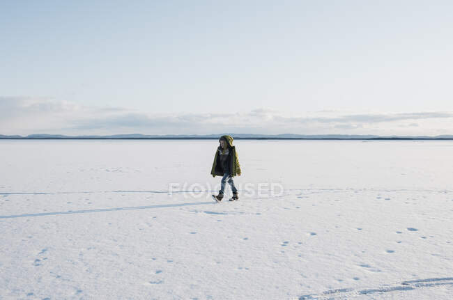 Boy walking across a frozen lake alone in Sweden — Stock Photo