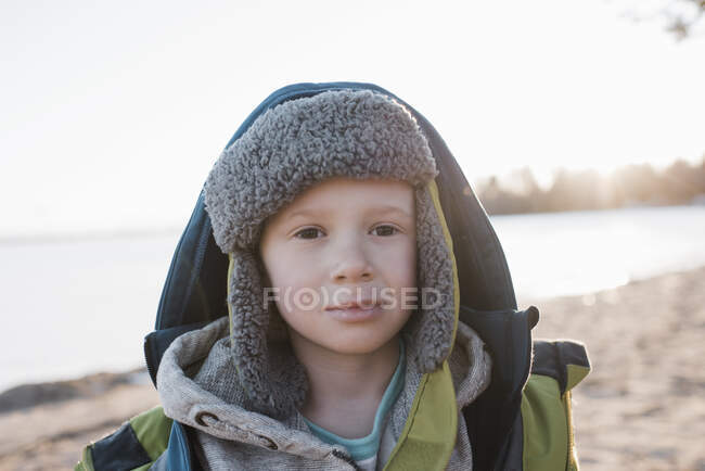 Portrait of boy at the beach at sunset in winter — Stock Photo