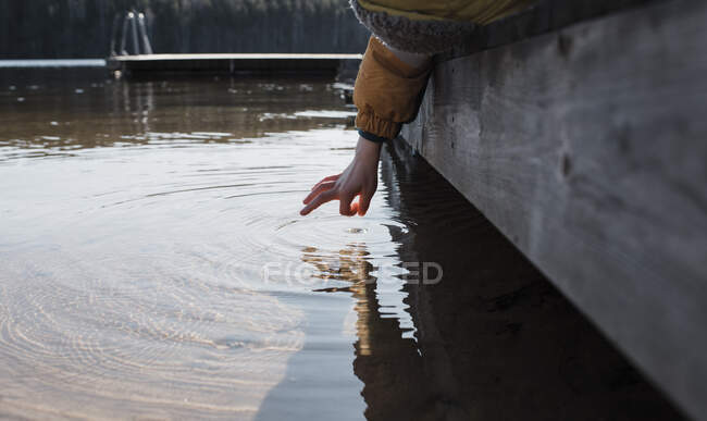 Mano del bambino che sventola acqua di mare sulla spiaggia in Svezia — Foto stock