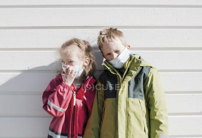 Siblings wearing medical masks to protect from corona virus — Stock Photo