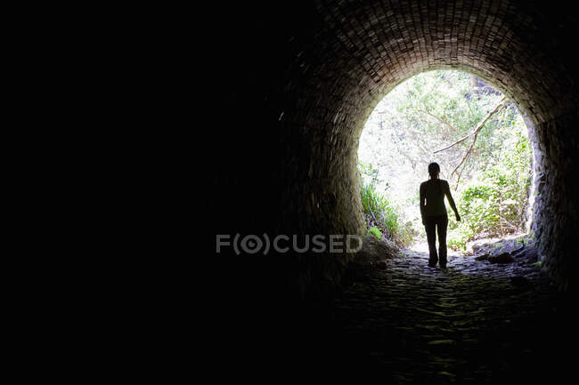 Mulher de pé em uma abertura do túnel — Fotografia de Stock