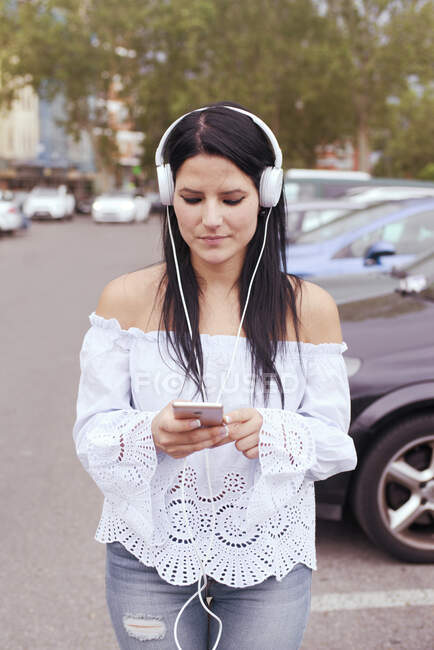 Молода жінка в Європі слухає музику з навушниками як ш. — стокове фото