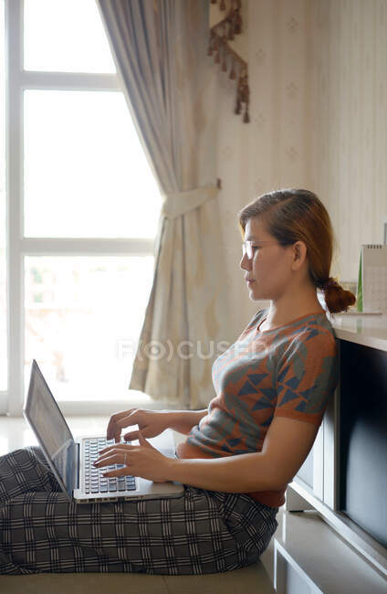 Mujer utilizar ordenador portátil para el trabajo desde casa - foto de stock