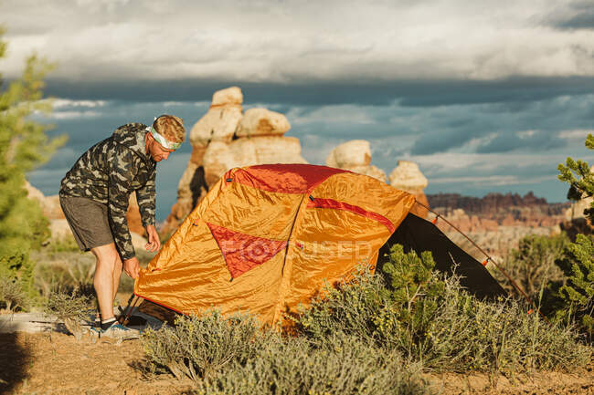 Man lay out the tent in desert — Stock Photo