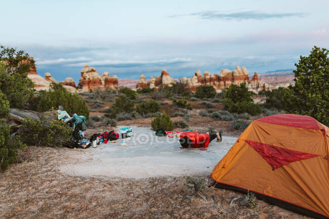 Camperin macht Liegestütze auf ihrem Zeltplatz in der Wüste Utahs — Stockfoto