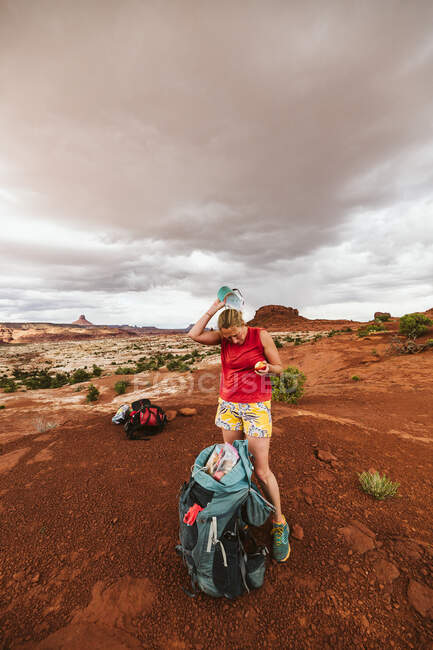 Eine junge Frau in Rot steht in der Wüste — Stockfoto