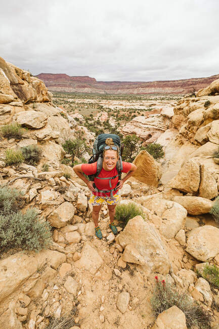 Una joven en rojo de pie en el desierto - foto de stock