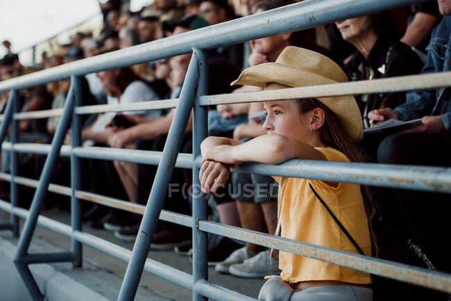 Little girl watching the rodeo with a cowboy hat on — Stock Photo
