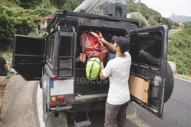 Гірський альпініст поклав рюкзак у багажник автомобіля — стокове фото