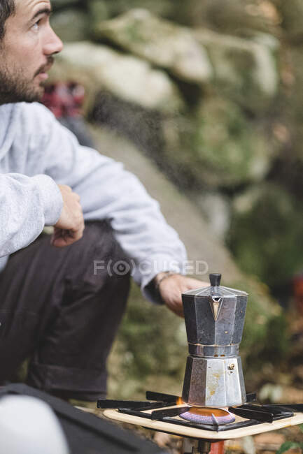 Un hombre prepara café al aire libre - foto de stock