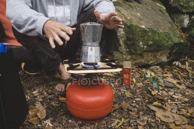 Lower part of a man preparing coffee outdoors — Stock Photo