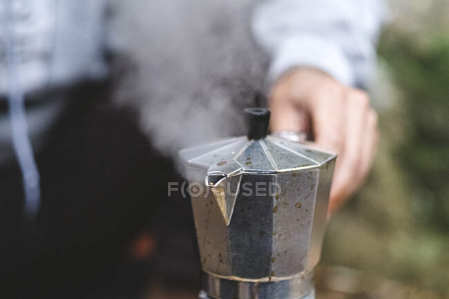 Primer plano de un hombre preparando café al aire libre - foto de stock
