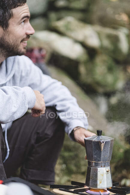 A man prepares coffee outdoors — Stock Photo
