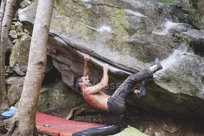 Un grimpeur masculin grimpe un rocher à l'extérieur — Photo de stock