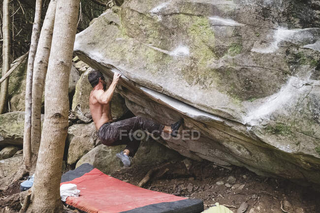 Un grimpeur masculin grimpe un rocher à l'extérieur — Photo de stock