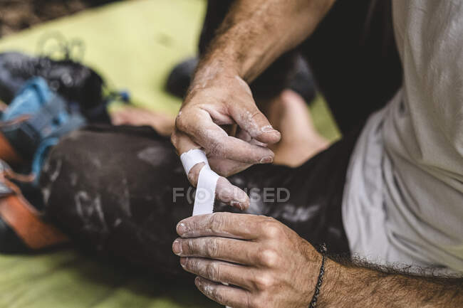 Nahaufnahme von Bergsteigerhänden, die sich die Finger zukleben — Stockfoto