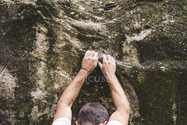 Parte superior de um alpinista do sexo masculino escalando uma rocha — Fotografia de Stock