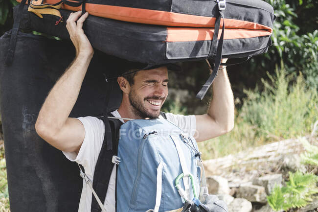 Portrait of a rock climber carrying crashpad and backpacks — Stock Photo