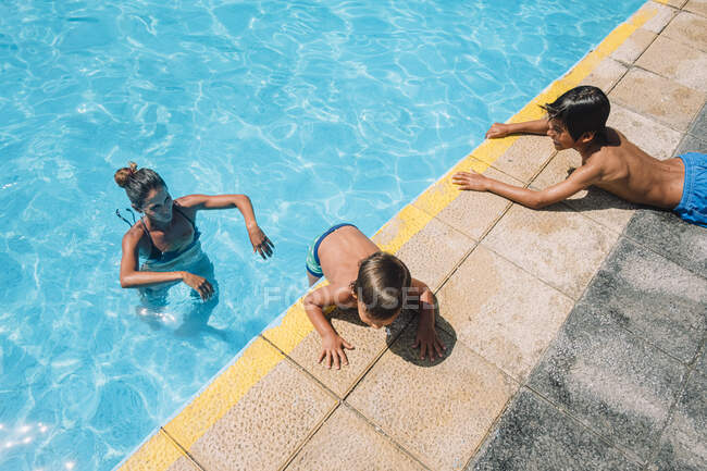 Familia jugando en una piscina - foto de stock