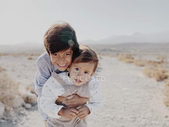 Porträt zweier Kinder, die sich in der Wüste umarmen — Stockfoto
