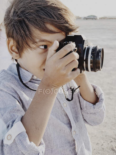 Close up portrait of a child taking a photo with a vintage camera — Stock Photo