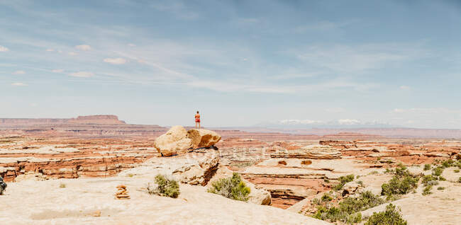 Panorama of a hiker standing on rock looking out over The Maze in Utah — Stock Photo