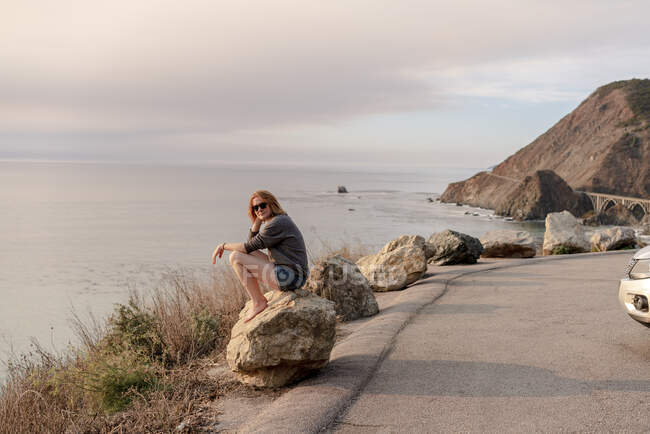 Donna seduta sulla roccia al Big Sur Punto di vista — Foto stock