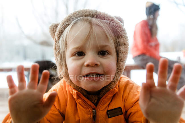 3 anni ragazza sorride attraverso la finestra a suo zio durante la quarantena — Foto stock