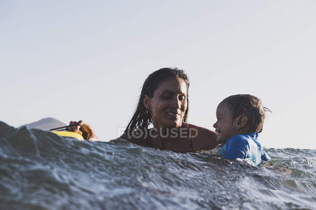 Mother and son surfing a small wave at sea — Stock Photo