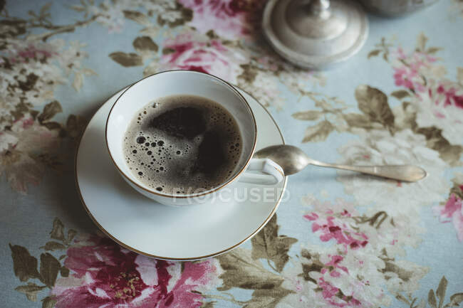 Taza de café y flores sobre un fondo blanco - foto de stock