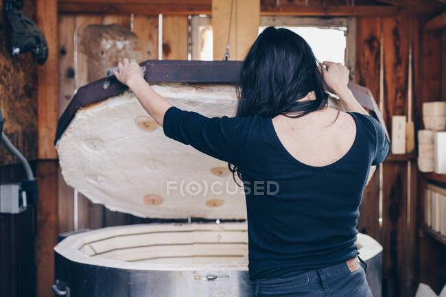 Artista aguarda corpo fundição pedaço de vidro infundido de fora do forno — Fotografia de Stock