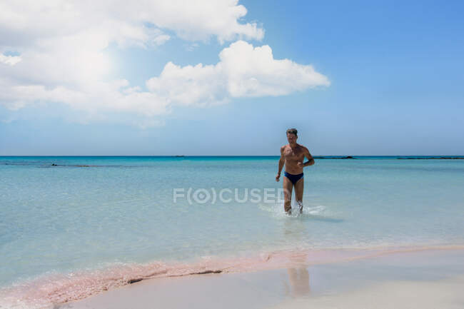 Paisagem com mar e homem desfrutando de água na praia de Elafonisi em — Fotografia de Stock