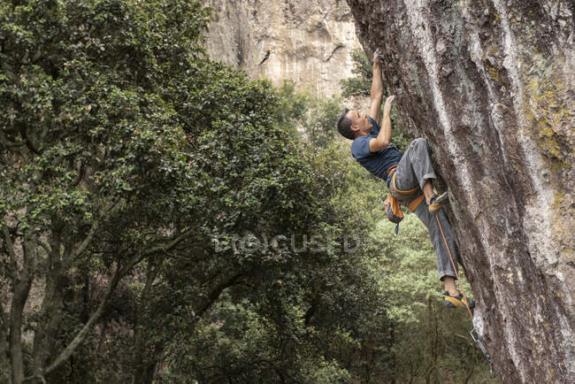 Молодой человек альпинист на скале — стоковое фото