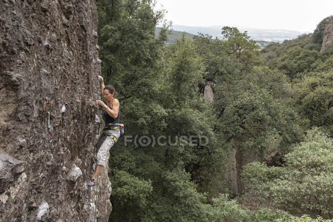 Молодая женщина взбирается на скалу — стоковое фото