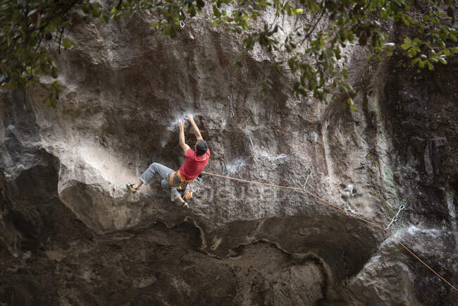 Junger Mann kletterte auf den Felsen — Stockfoto