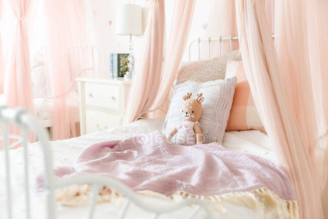 Little girl bed with stuffed animal — Stock Photo