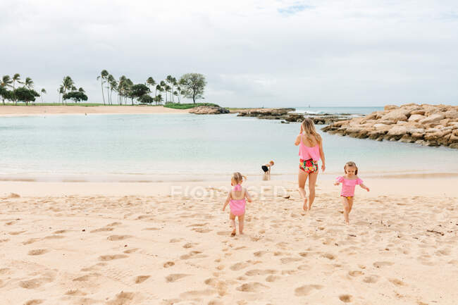 Mãe com crianças brincando na praia — Fotografia de Stock
