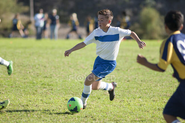 Joueurs de football jouant au football sur le terrain — Photo de stock