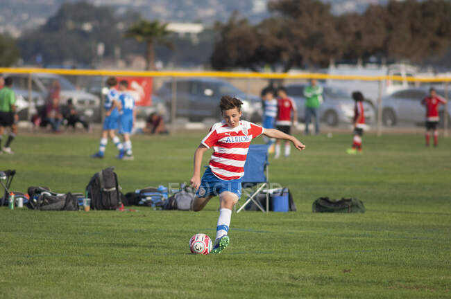 Adolescente jogador de futebol prestes a bater a bola em um chute livre — Fotografia de Stock